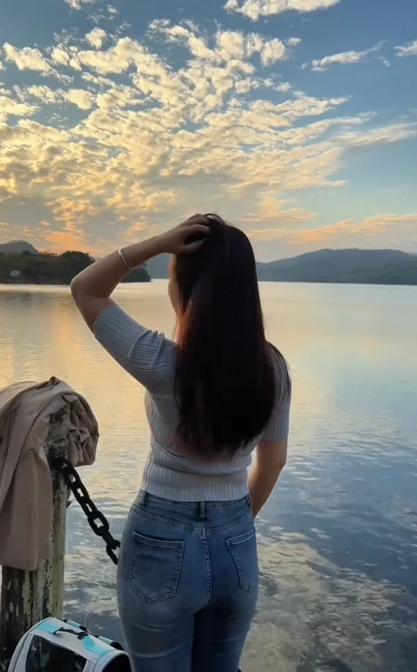 2. Una mano en la cintura, otra jugando con el pelo, mirando a lo lejos