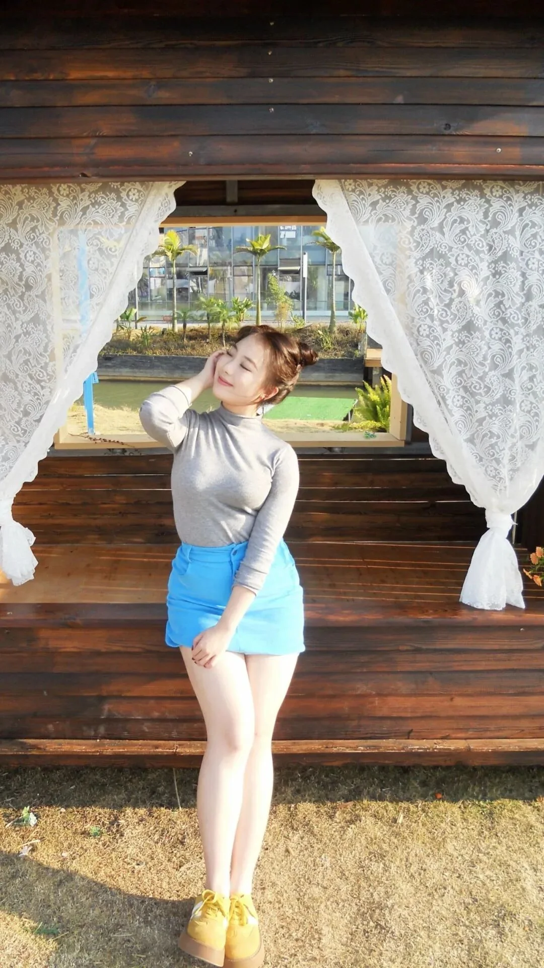 1. De pie con un pie ligeramente doblado, jugando con el pelo, cabeza girada, ojos cerrados y sonrisa